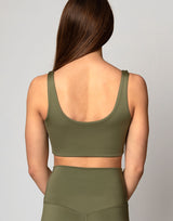 woman wearing v neck crop in moss green color on grey background