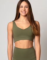 woman wearing v neck crop in moss green color on grey background