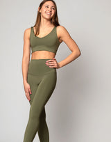 woman wearing v neck crop in moss green color on grey background