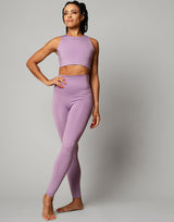 woman wearing legging and crop top set in lavender purple on grey background