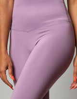 woman wearing legging in lavender purple on grey background