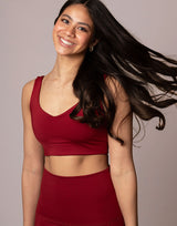 woman wearing v neck crop in cranberry red on grey background