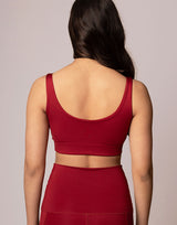 woman wearing v neck crop in cranberry red on grey background