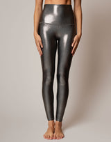 Shiny silver leggings worn by a person on a neutral background
