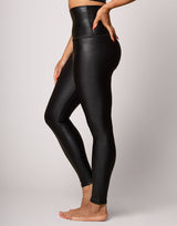 woman wearing high shine and sparkling jet black colored legging on grey background