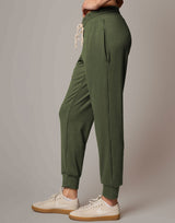 Green jogger pants worn by a person on a gray background
