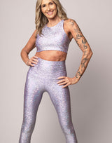 woman wearing crop top with mermaid pattern of lavender purple colored sparkling fish scales on grey background
