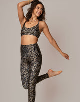 woman wearing leopard print sports bra against grey background