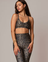 woman wearing leopard print sports bra against grey background