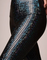 woman wearing legging with mermaid pattern of midnight black colored sparkling fish scales on grey background