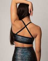 woman wearing sports bra with mermaid pattern of midnight black colored sparkling fish scales on grey background