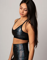 woman wearing sports bra with mermaid pattern of midnight black colored sparkling fish scales on grey background