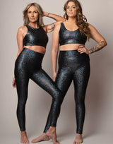 women wearing crop top and legging set with mermaid pattern of midnight black colored sparkling fish scales on grey background