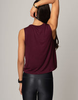 woman wearing burgundy colored tank on grey background