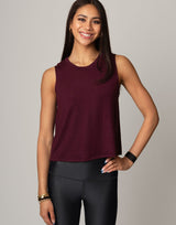 woman wearing burgundy colored tank on grey background