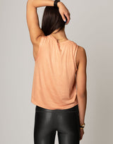 woman wearing peach colored tank on grey background