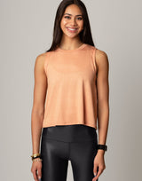 woman wearing peach colored tank on grey background