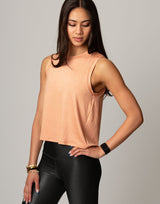 woman wearing peach colored tank on grey background