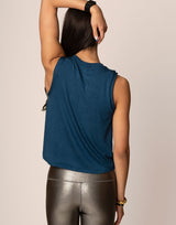 woman wearing teal colored tank on grey background
