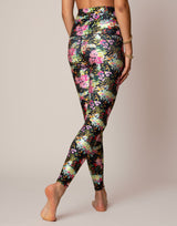 woman wearing vivid and colorful floral designs printed legging on grey background