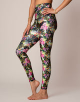 woman wearing vivid and colorful floral designs printed legging on grey background
