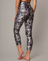 Person wearing black and white floral leggings on a gray background