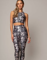 Woman wearing a black and white floral athletic outfit on a gray background