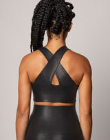 Person wearing a black sports bra and leggings set on a plain background