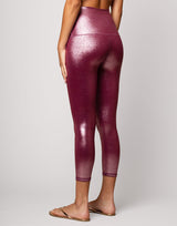 woman wearing high shine and sparkling pink colored legging on grey background