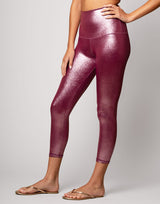 woman wearing high shine and sparkling pink colored legging on grey background