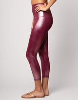 woman wearing high shine and sparkling pink colored legging on grey background