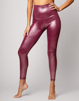 woman wearing high shine and sparkling pink colored legging on grey background