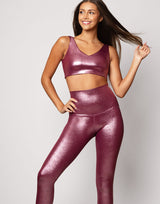 woman wearing high shine and sparkling pink colored legging and top set on grey background