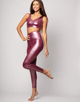 woman wearing high shine and sparkling pink colored legging on grey background