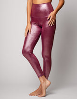 woman wearing high shine and sparkling pink colored legging on grey background