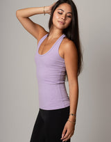 Woman wearing a purple tank top against a gray background