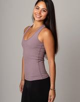 Woman wearing a mauve tank top against a gray background