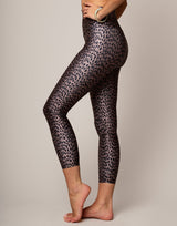 Person wearing leopard print leggings on a plain background
