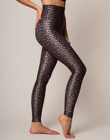 Person wearing black leopard print leggings on a plain background