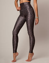 Person wearing leopard print leggings on a plain background