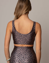 Person wearing a leopard print top and skirt set on a neutral background