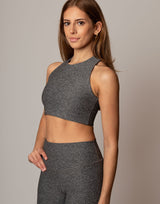 Woman wearing a gray athletic outfit against a plain background