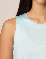 woman wearing light blue colored tank on grey background