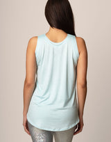 woman wearing light blue colored tank on grey background
