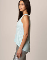 woman wearing light blue colored tank on grey background