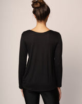 woman wearing long sleeve top in black on grey background