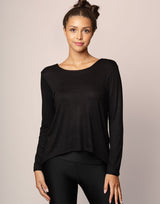 woman wearing long sleeve top in black on grey background