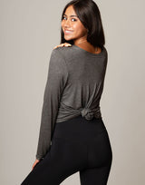 woman wearing long sleeve top in charcoal grey on grey background