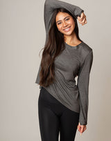 woman wearing long sleeve top in charcoal grey on grey background