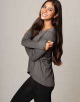woman wearing long sleeve top in charcoal grey on grey background
